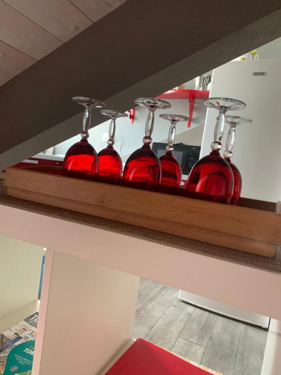 a row of red wine bottles on a shelf at Nonno Pinin in Turin