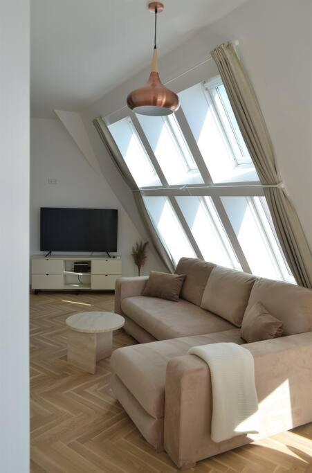 a living room with a couch and a large window at Luxury apartment with a balcony and view in Riga Old Town in Riga
