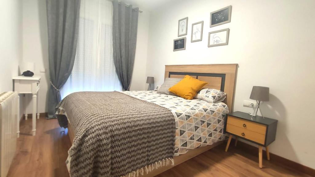 a bedroom with a bed and a dresser and a window at El Racó de la Vero in Falset