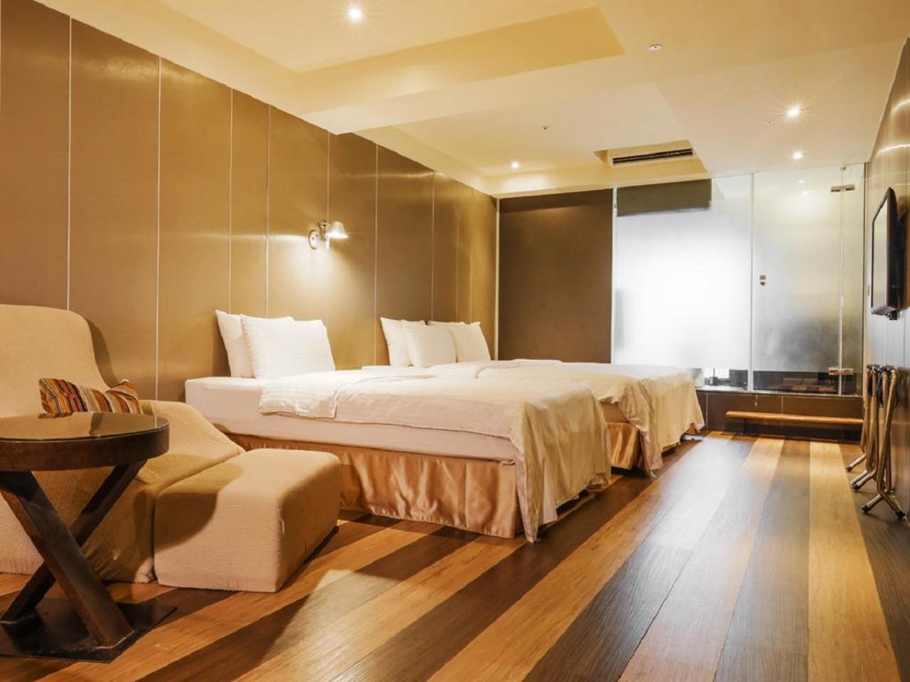 a hotel room with two beds and a chair at Hotel Relax I in Taipei