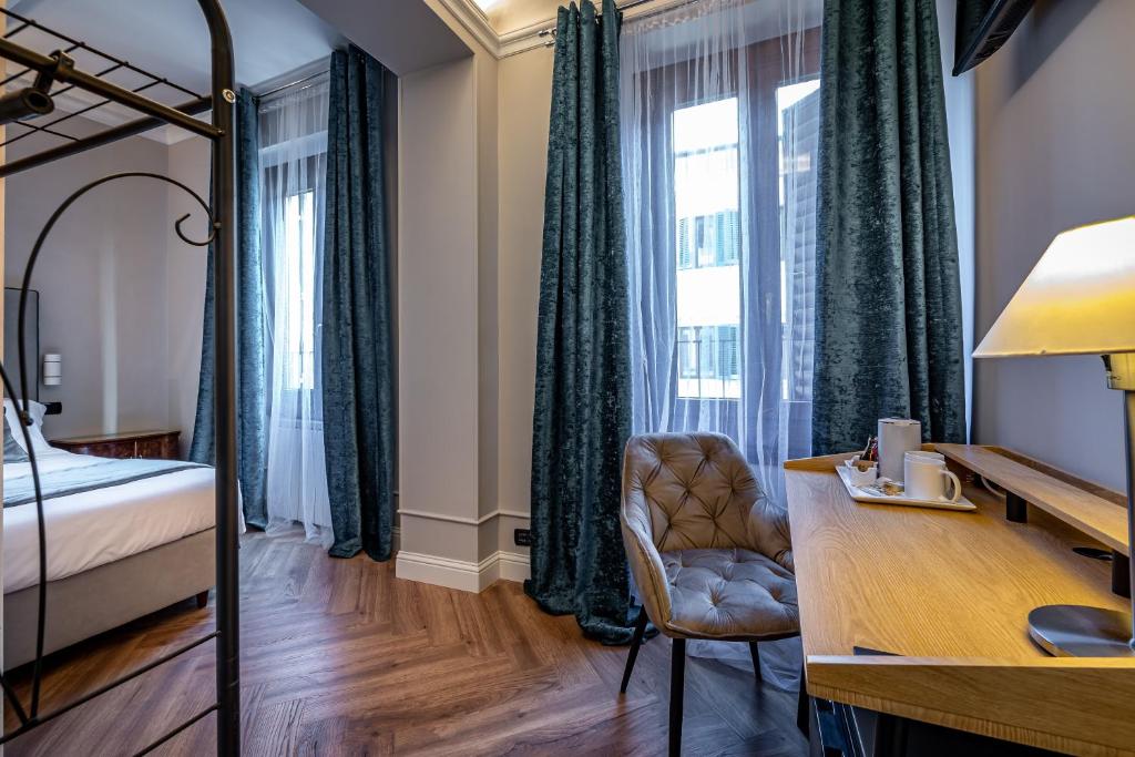een slaapkamer met een bed en een bureau met een stoel bij Boutique Hotel Borgo in Florence