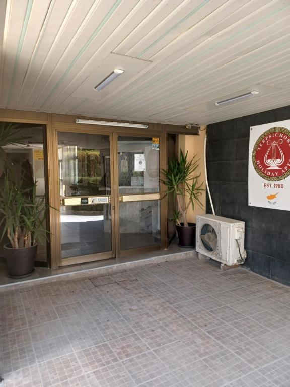 a building with glass doors and a sign on the wall at TERPSICHORE Holiday Apts in Limassol
