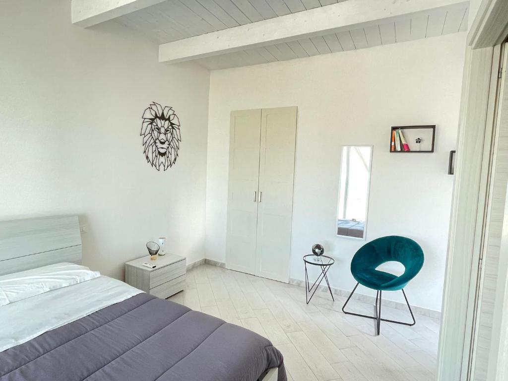 um quarto com uma cama e uma cadeira azul em CARFAGNINI ROOMS em Termoli