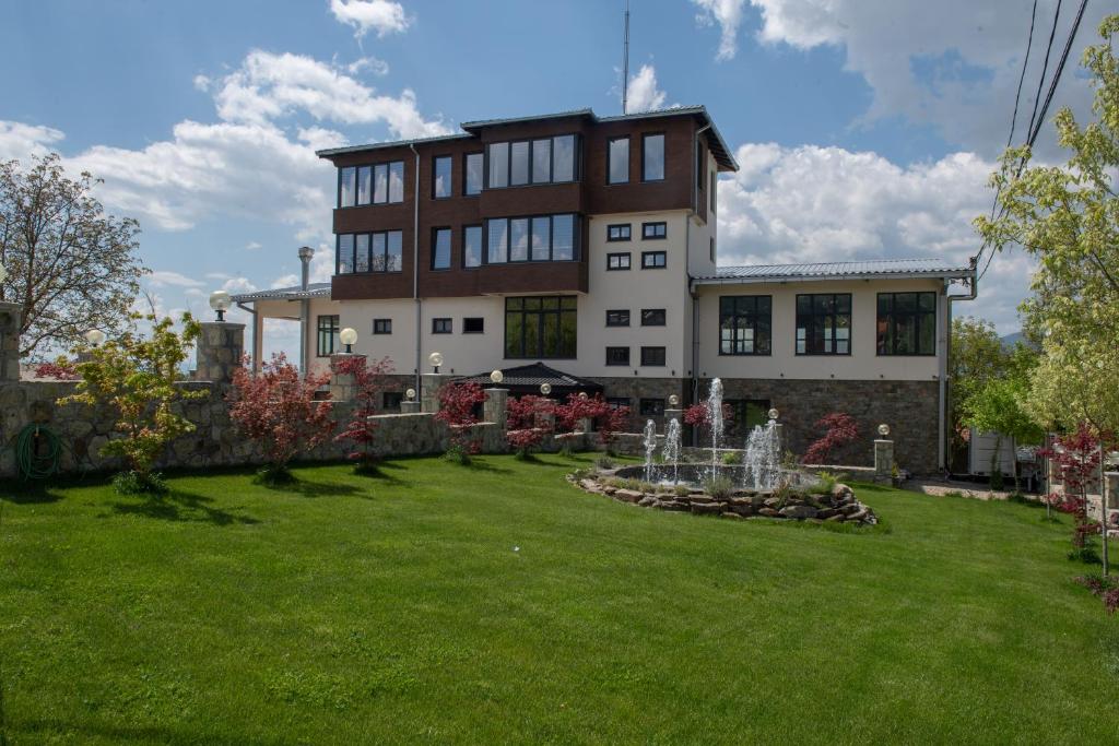 a large building with a fountain in a yard at Zoo Misic Prenoćište in Vranje