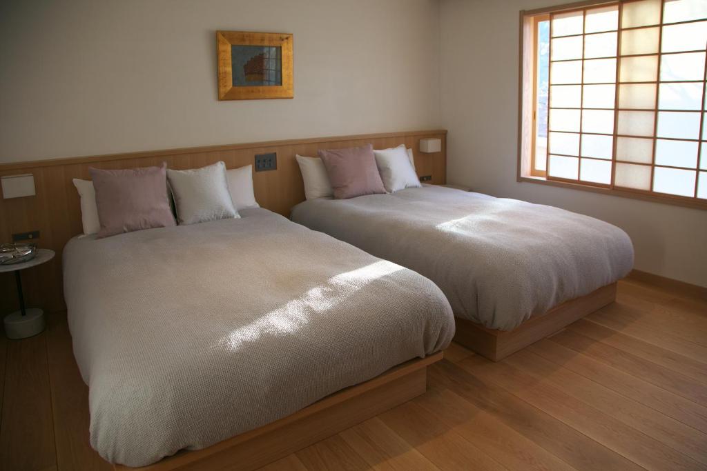Postel nebo postele na pokoji v ubytování Arima Onsen Takayamaso Hanano