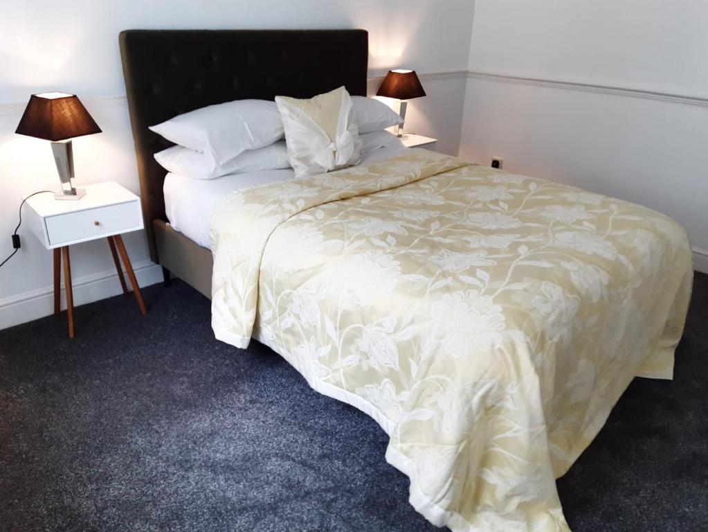 1 dormitorio con 1 cama grande y 2 lámparas en Cheerful home close to the city and Peak District en Neepsend