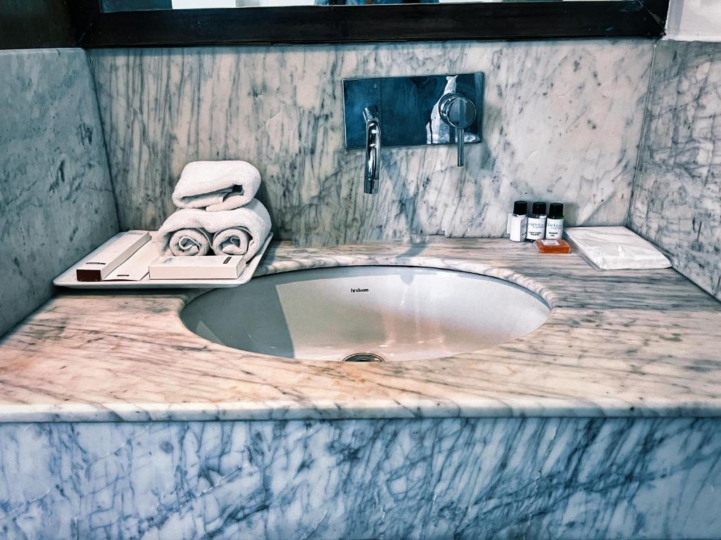 bagno in marmo con lavandino e portasciugamani di The Orion Express a Jaipur