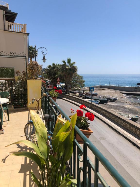 balcón con bancos y vistas al océano en Hostel Beach House en Giardini Naxos