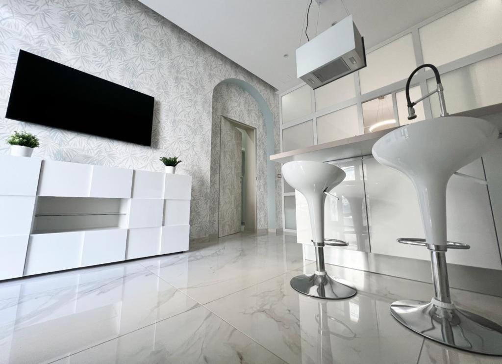 een woonkamer met witte meubels en een flatscreen-tv bij THE HOUSE OF EVELYN in Catania