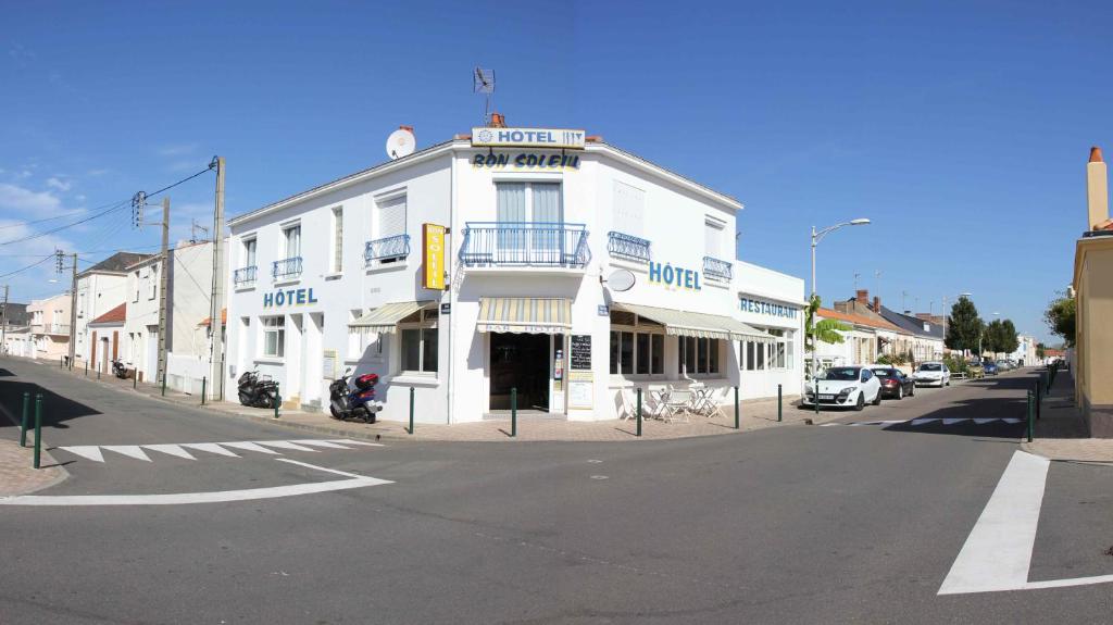 un edificio blanco en la esquina de una calle en Hotel le Bon Soleil, en Les Sables-dʼOlonne