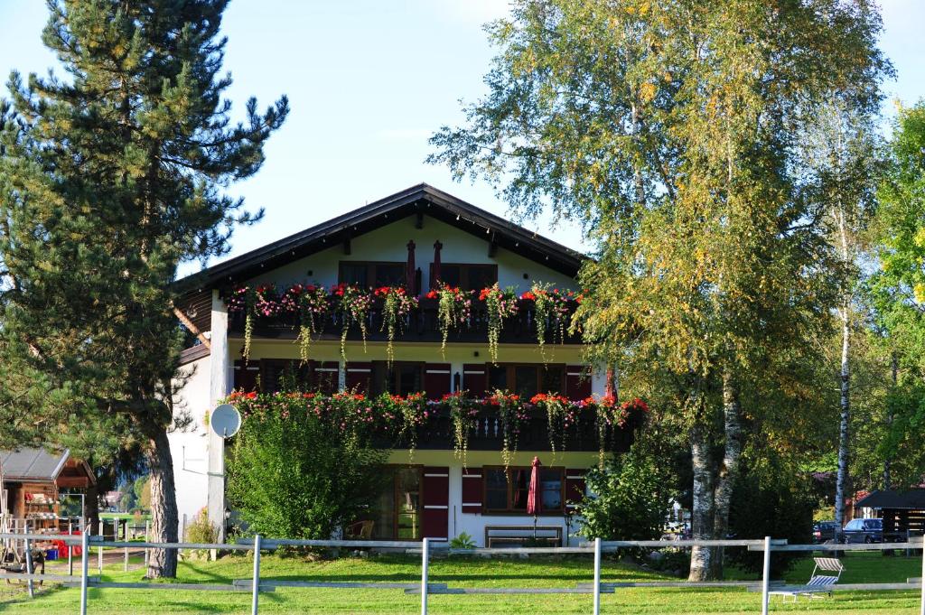 - un bâtiment avec un balcon fleuri dans l'établissement Der Landhof, à Oberstdorf