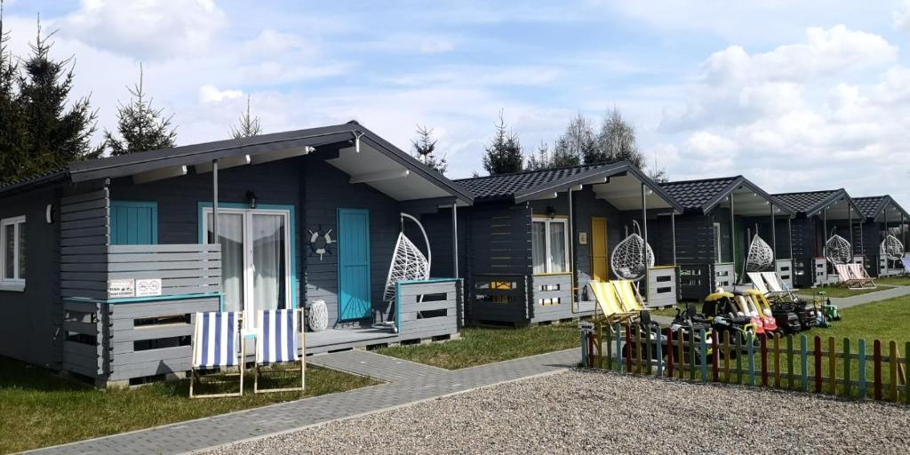 a blue house with a fence in front of it at WAKACYJNE ZAGAJE in Sarbinowo