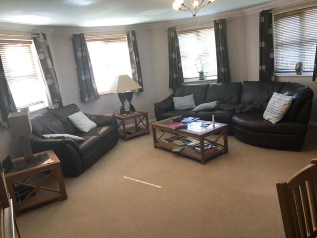 a living room with couches and a coffee table at Captivating Apartment in Copthorne near Gatwick in Copthorne