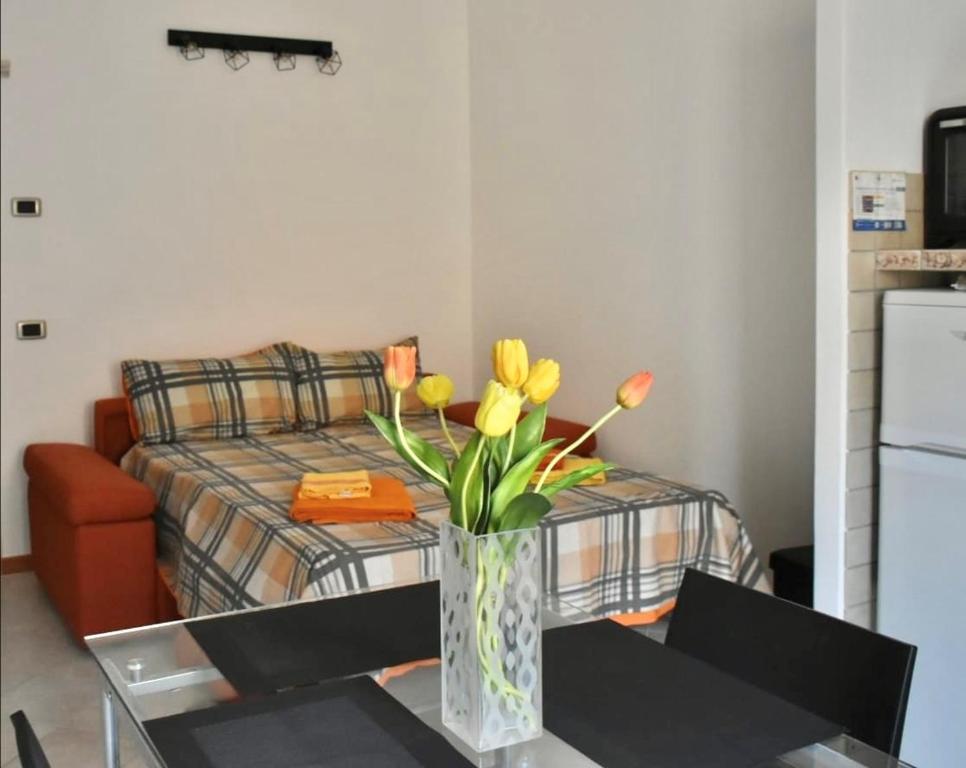 eine Vase mit Blumen auf einem Tisch im Wohnzimmer in der Unterkunft Civico 22 in Trapani