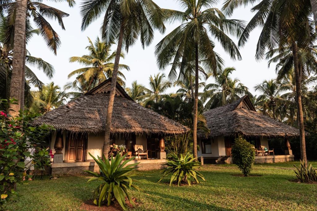 a resort with palm trees in the background at Neeleshwar Hermitage in Nīleshwar