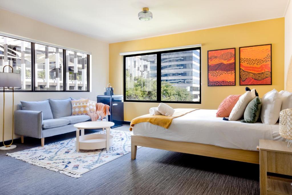 - une chambre avec un grand lit et un canapé dans l'établissement Selina Brisbane, à Brisbane