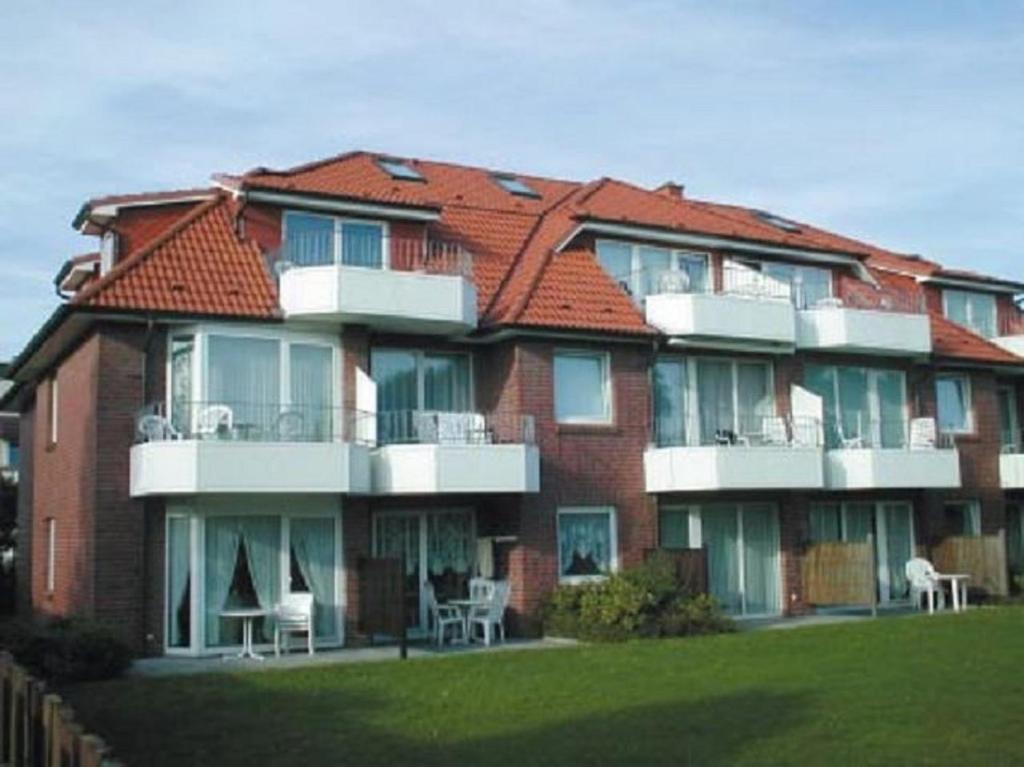 un gran edificio de ladrillo rojo con balcones blancos en Oasis 09, en Cuxhaven