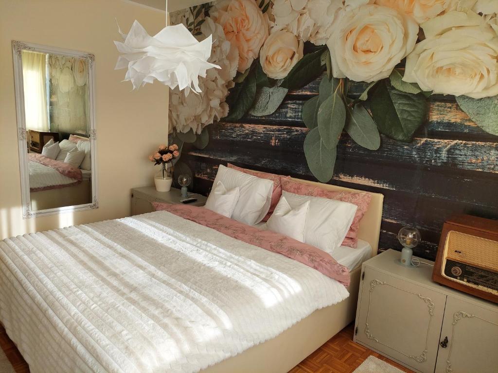 1 dormitorio con 1 cama con flores en la pared en Retro Cosy Apartment, en Mirijevo