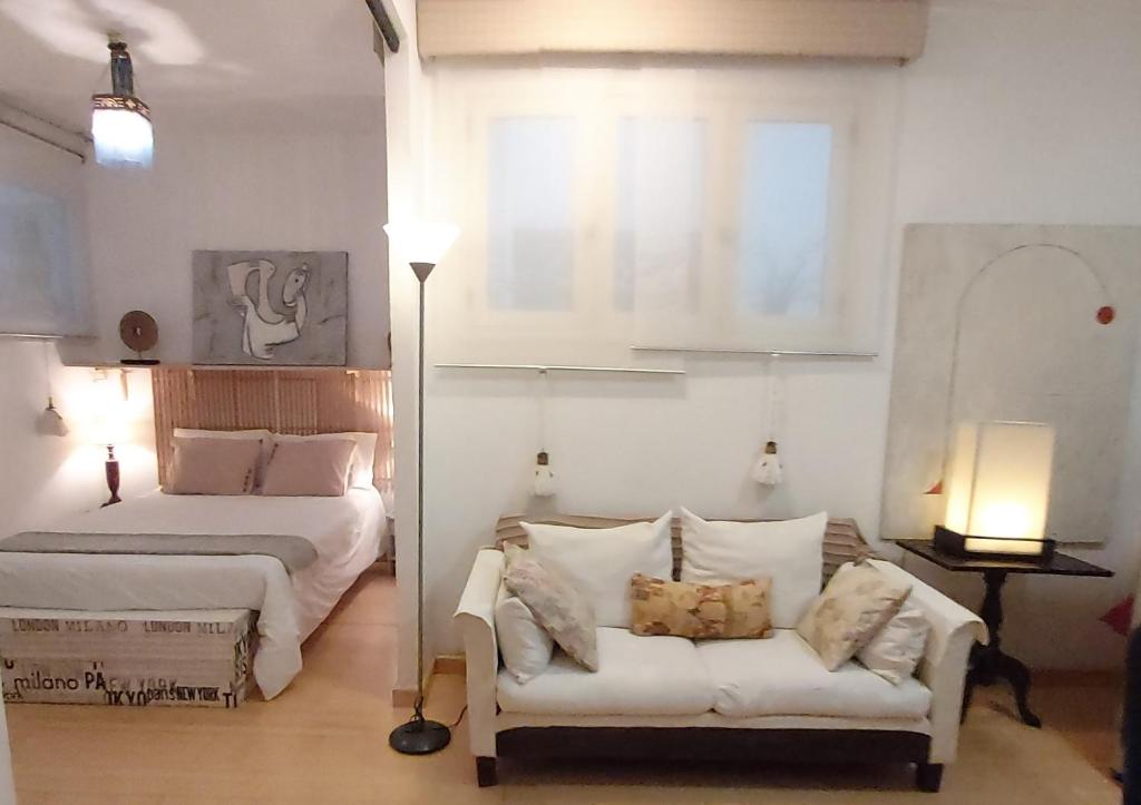 a bedroom with a bed and a couch and a window at Habitacion en apartamento Vegueta in Las Palmas de Gran Canaria