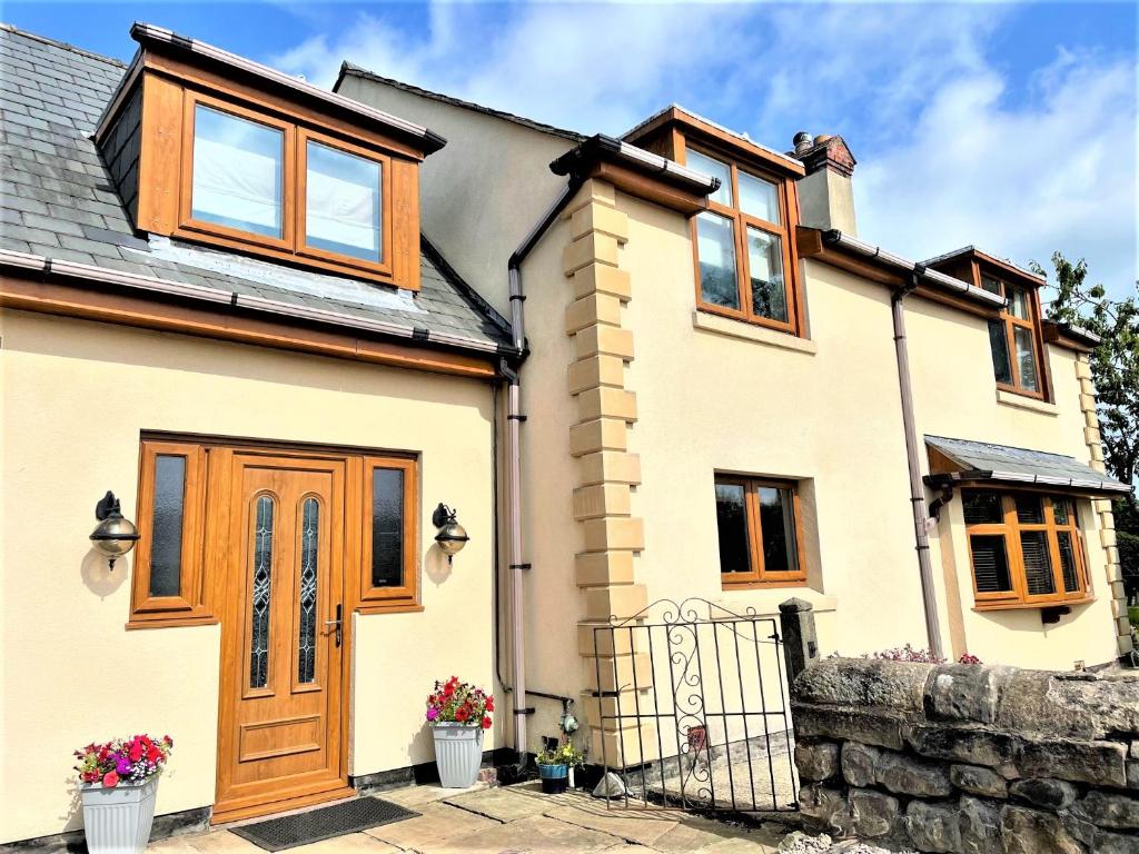 a white house with wooden doors and windows at Abbey Farm House Ormskirk in Ormskirk