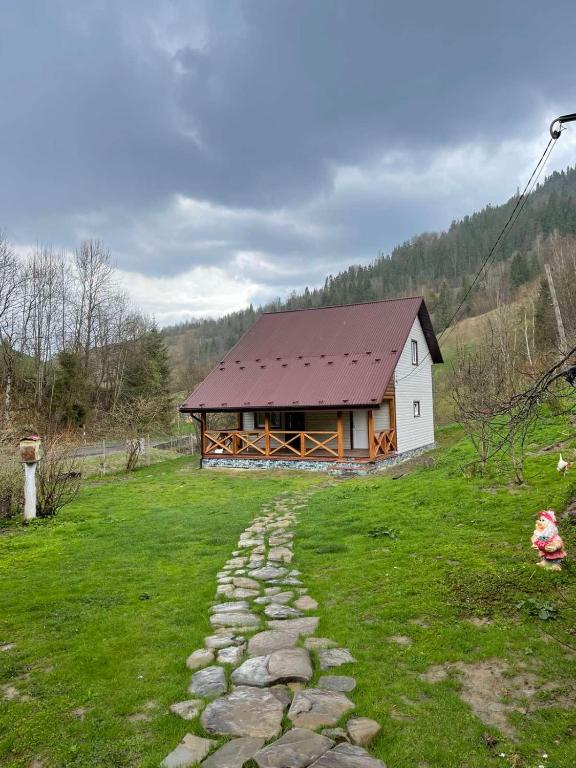 a house with a stone path in front of it at Медові Карпати in Oryavchyk