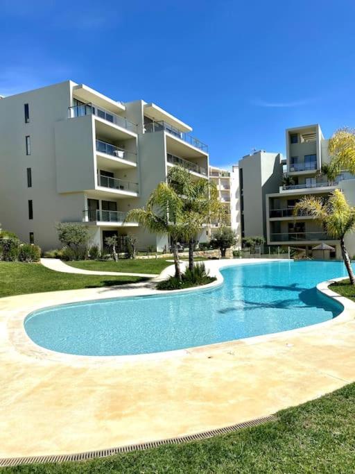 a swimming pool in front of a building at NEW STUNNING OCEAN APRT IN "OASIS MAR" Wi-Fi in Portimão
