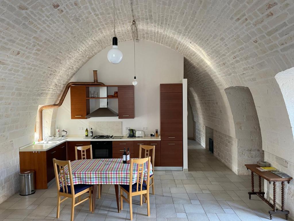 kuchnia i jadalnia ze stołem w łuku w obiekcie Casa Trieste w Alberobello