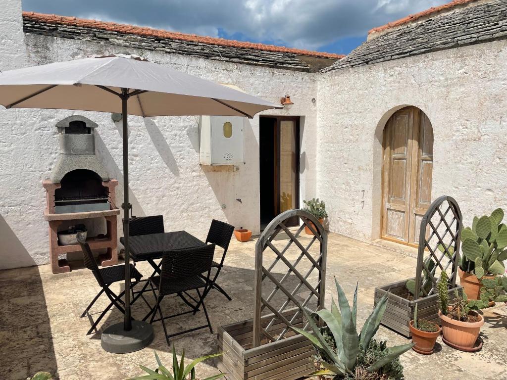 taras z parasolem, stołem i krzesłami w obiekcie Casa Trieste w Alberobello