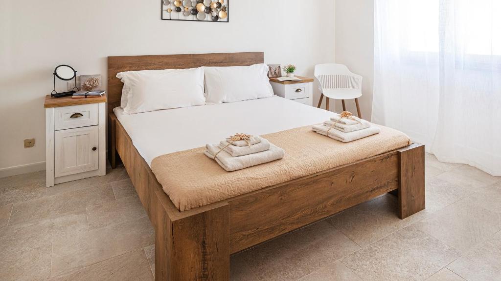 a bedroom with a large bed with two towels on it at Welcomely - Coral Coast Alghero in Alghero