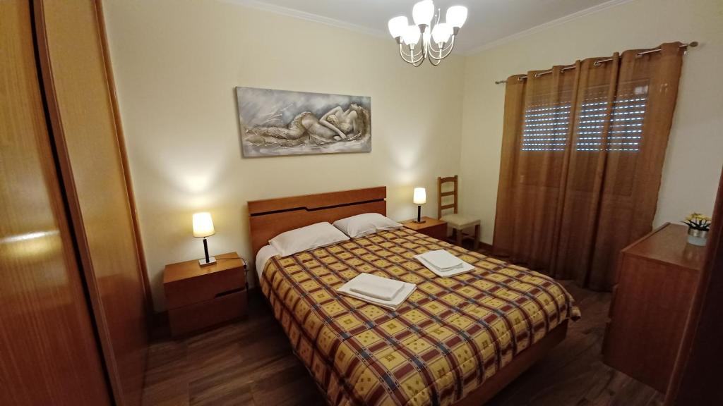 a bedroom with a bed with two tables and two lamps at Dona Matilde in Ponta Delgada