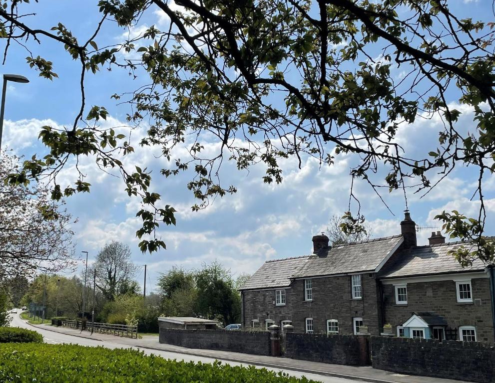 een oud bakstenen huis op een weg naast een straat bij Rose Cottage in Abergavenny