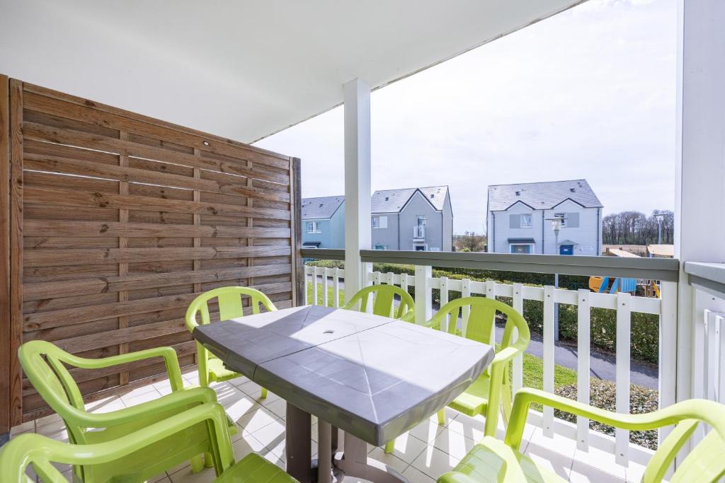 un patio avec une table et des chaises sur un balcon dans l'établissement Le Bécasseau Sanderling, à Courseulles-sur-Mer