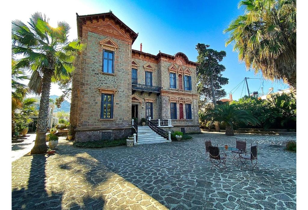 an old house with palm trees in front of it at The Loriet in Mytilene