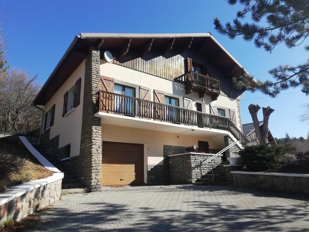 une maison avec un balcon au-dessus dans l'établissement 1.2.3 SOLEIL, à Barcelonnette