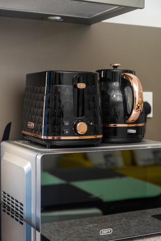 a toaster and coffee pot sitting on top of a microwave at C-view Apartments in Flic-en-Flac