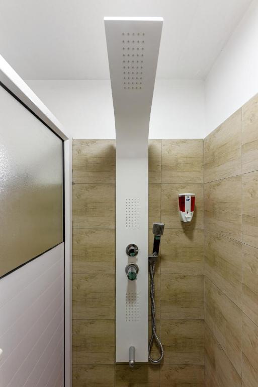 a walk in shower with a glass door and a shower at C-view Apartments in Flic-en-Flac