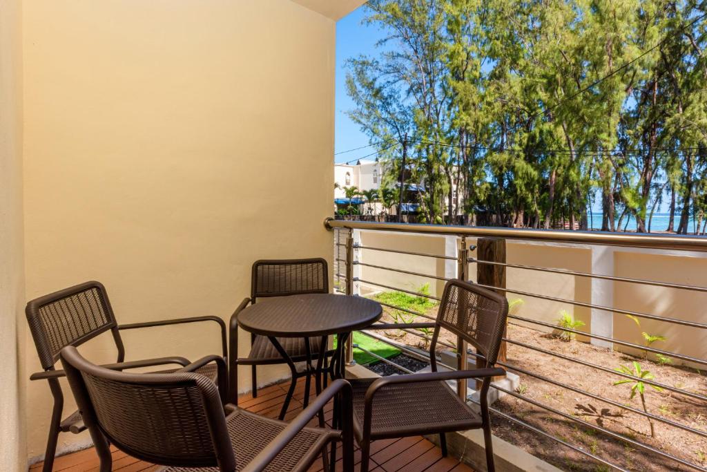 a balcony with chairs and a table and a table at C-view Apartments in Flic-en-Flac