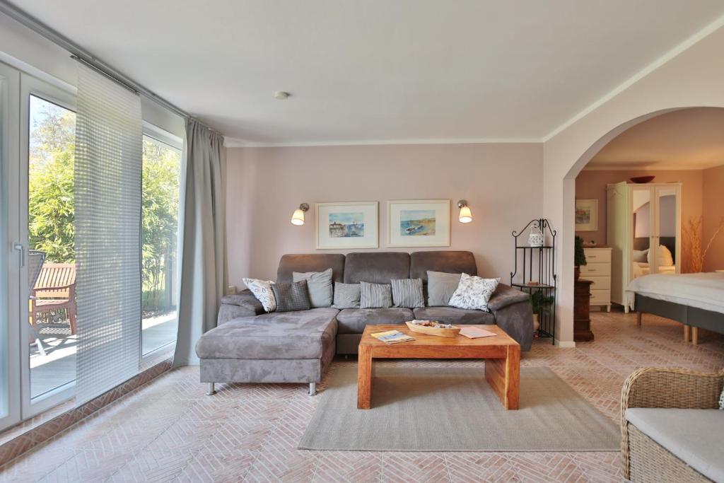 ein Wohnzimmer mit einem Sofa und einem Tisch in der Unterkunft Ferienbungalow Erlenweg 20 Erlenweg 20 Appartement 2 Niendorf Ostsee in Niendorf
