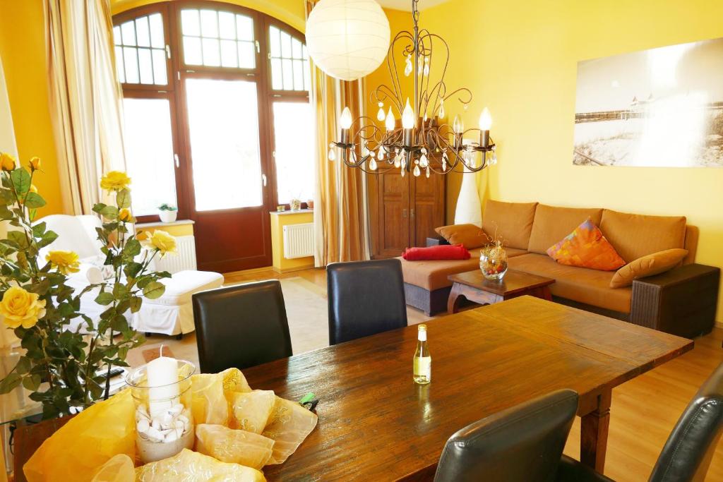 ein Wohnzimmer mit einem Tisch und einem Sofa in der Unterkunft Villa Medici App_ 02 in Ahlbeck