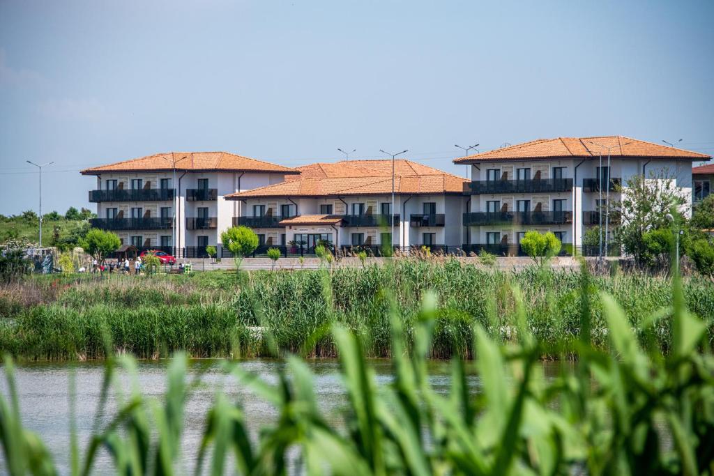 a group of buildings in front of a body of water at Popasul Pescarilor Fishing Village in Olimp