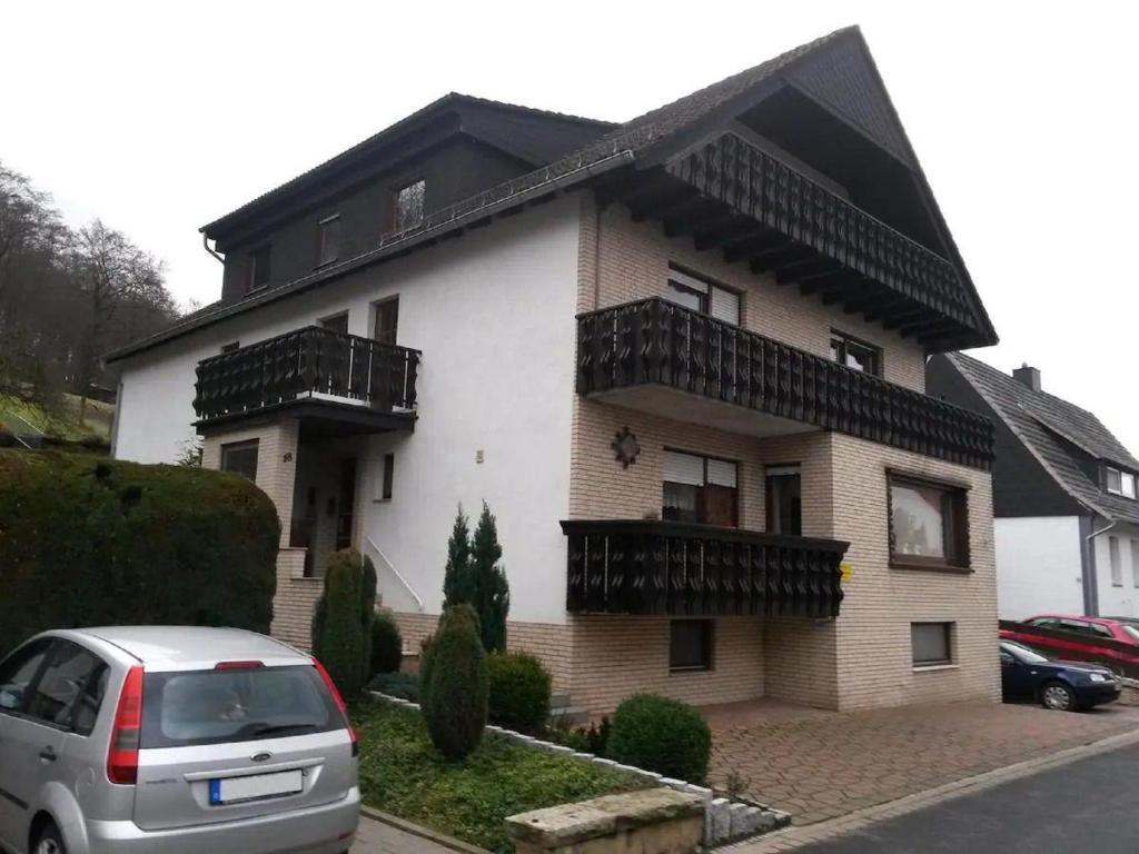 uma casa com um carro estacionado em frente em Ferienwohnung Am Waldrand em Bad Driburg