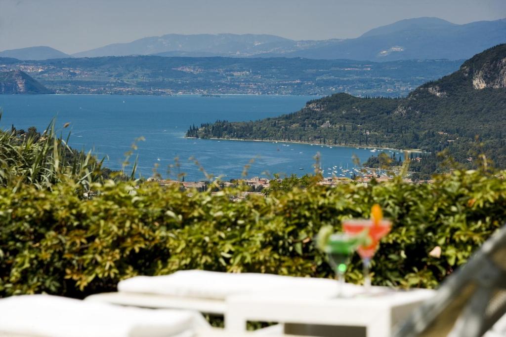 a view of a lake from a table with a drink at Boffenigo Panorama & Experience Hotel in Costermano