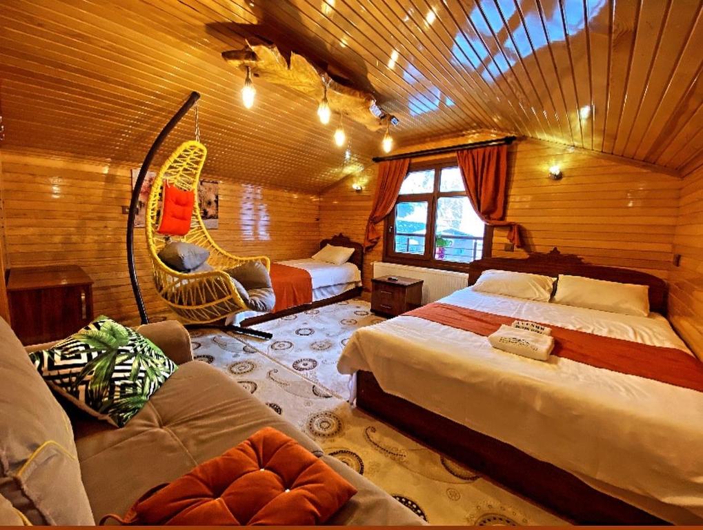 een slaapkamer met 2 bedden en een schommel bij Ayder Avusor Hotel in Ayder Yaylasi