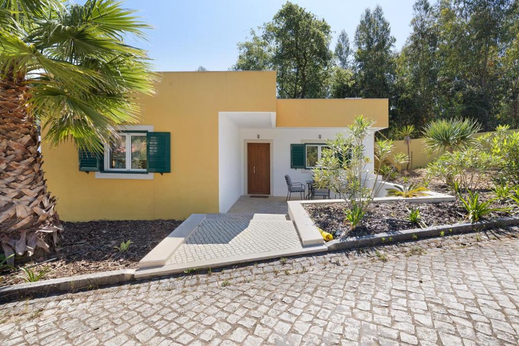 Casa amarilla con patio y entrada en Quinta Vitae en Gradil