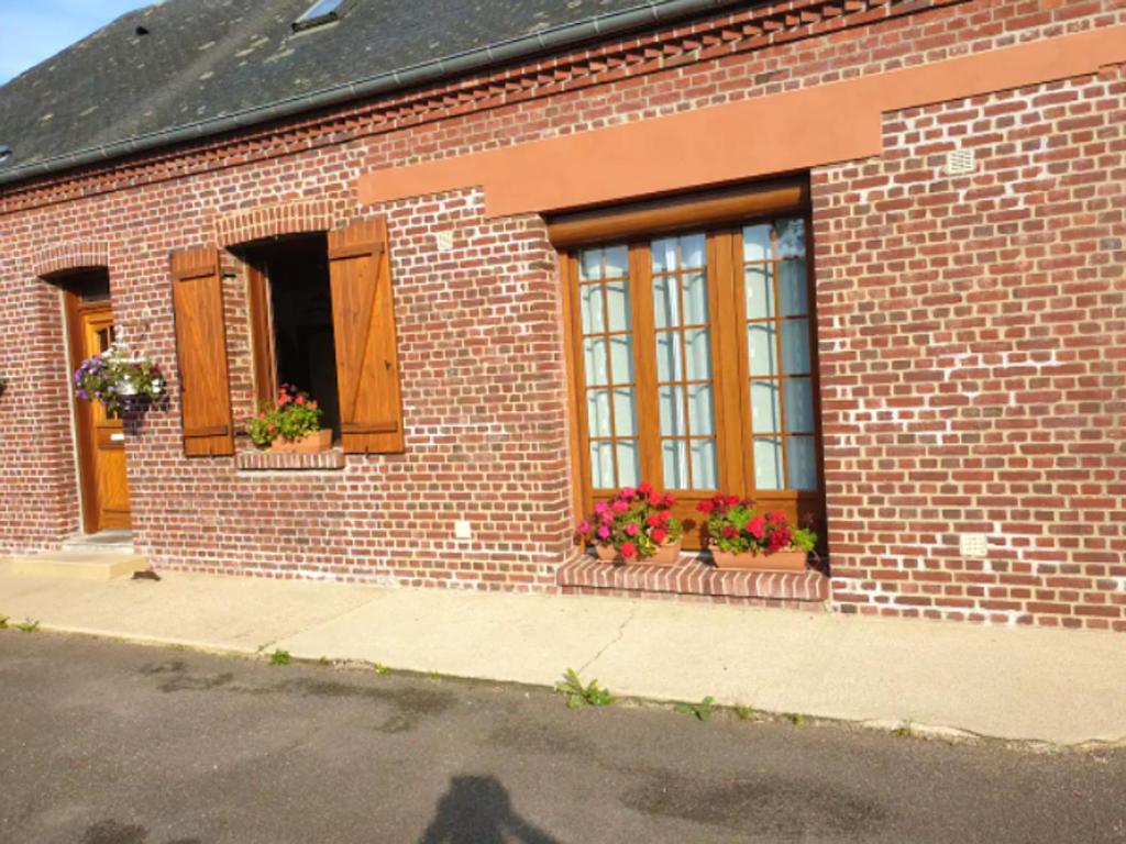 ein Backsteingebäude mit Fenstern und Blumenkästen darauf in der Unterkunft Maison de 3 chambres avec jardin clos et wifi a Londinieres in Clais