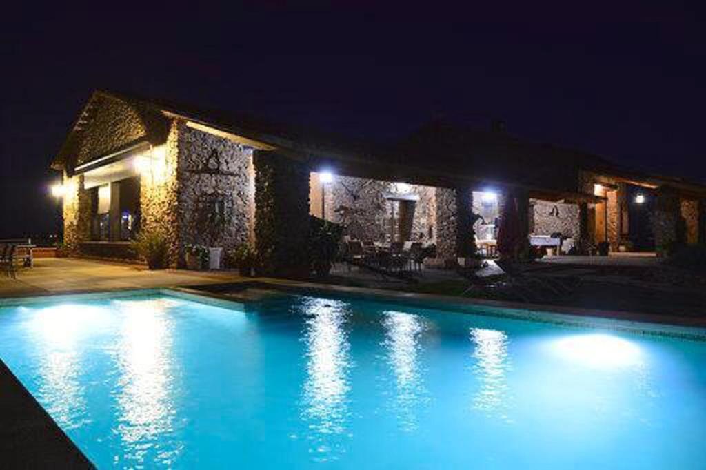 a swimming pool in front of a house at night at 4 bedrooms villa with private pool enclosed garden and wifi at Fernan Caballero in Fernancaballero
