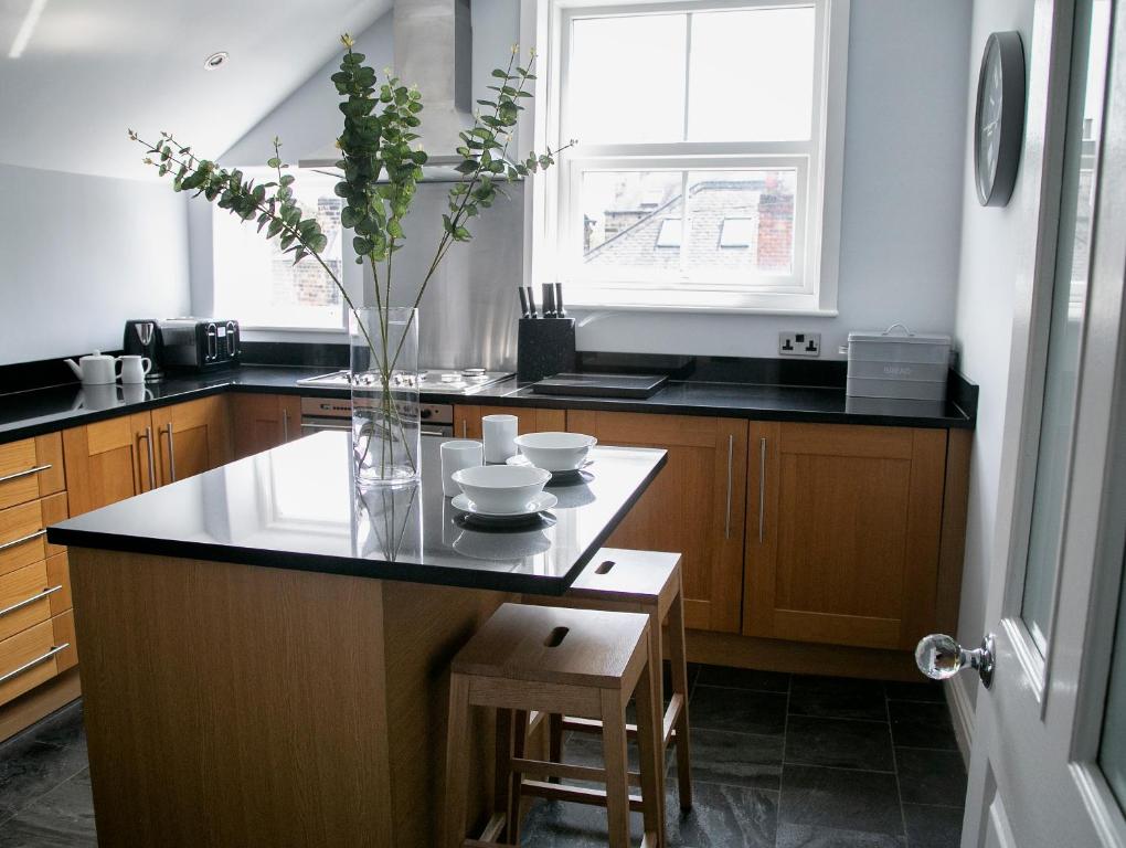 a kitchen with a counter with a vase with flowers in it at Harlow Apartment 3 in Harrogate
