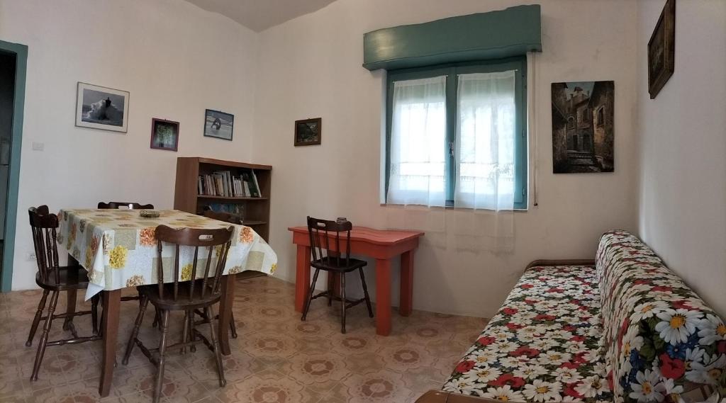 Habitación con mesa, cama y ventana en Casa Vacanze Else, en Lazzaro