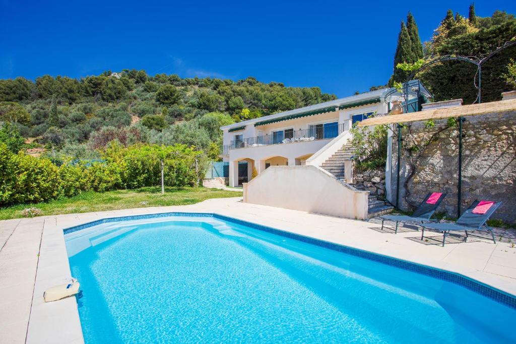 a swimming pool with two chairs and a house at Vinaigrier Hills VI3086 by Riviera Holiday Homes in Nice