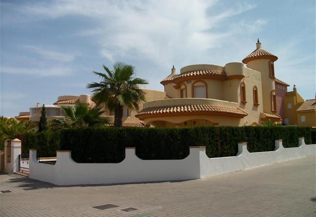 duży dom z białym płotem przed nim w obiekcie Luxury villa w mieście Islantilla